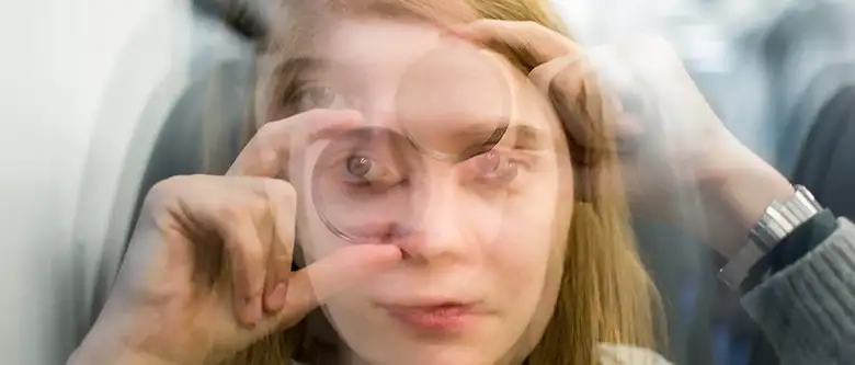 blurred woman looking at magnifying glass