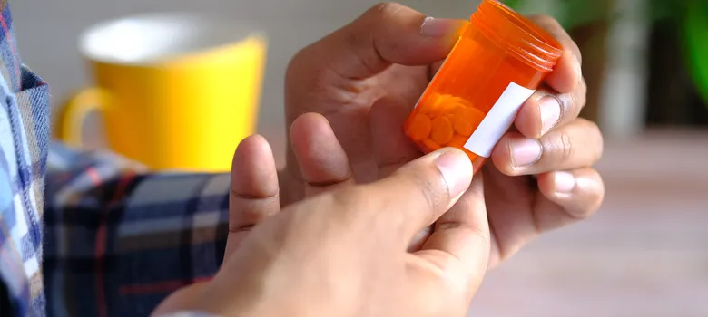rear-view-young-man-hand-hold-medical-pill-container